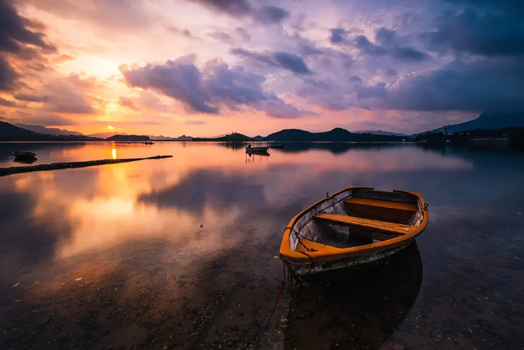 beautiful-shot-small-lake-with-wooden-rowboat-focus-breathtaking-clouds-sky